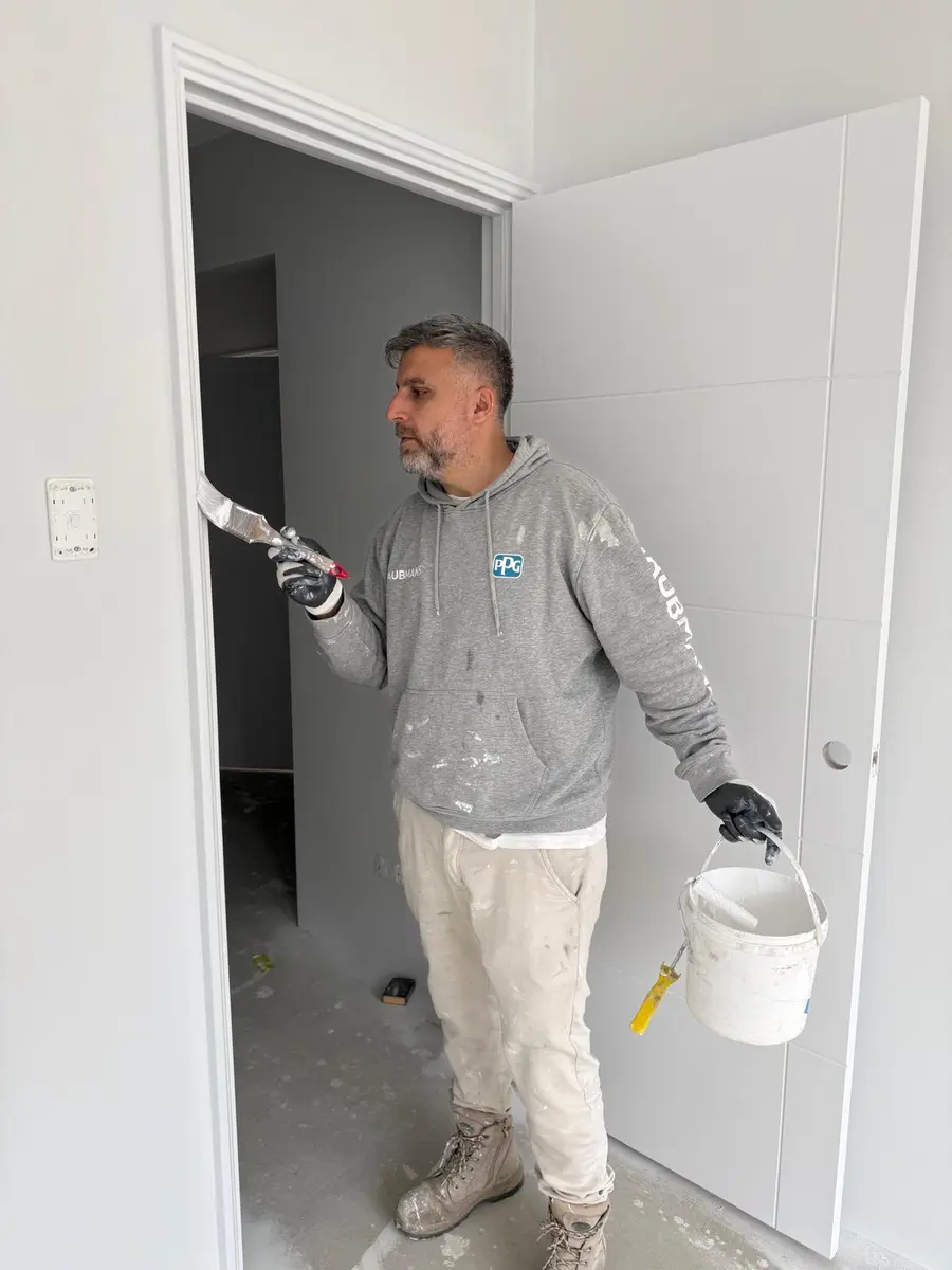 Kevin cutting in around a door frame by brush