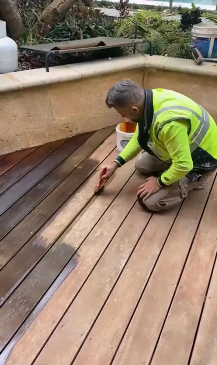Kevin applying oil to timber decking boards