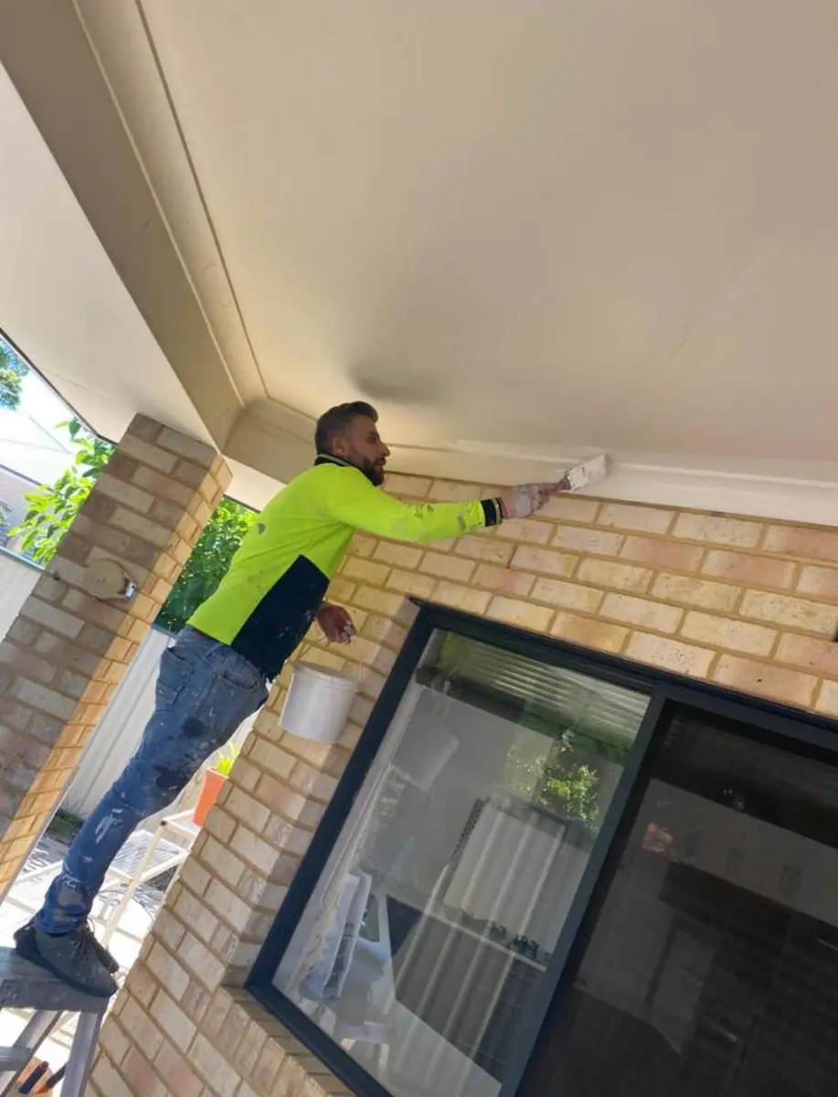Kevin painting the eaves of a brick home in Perth