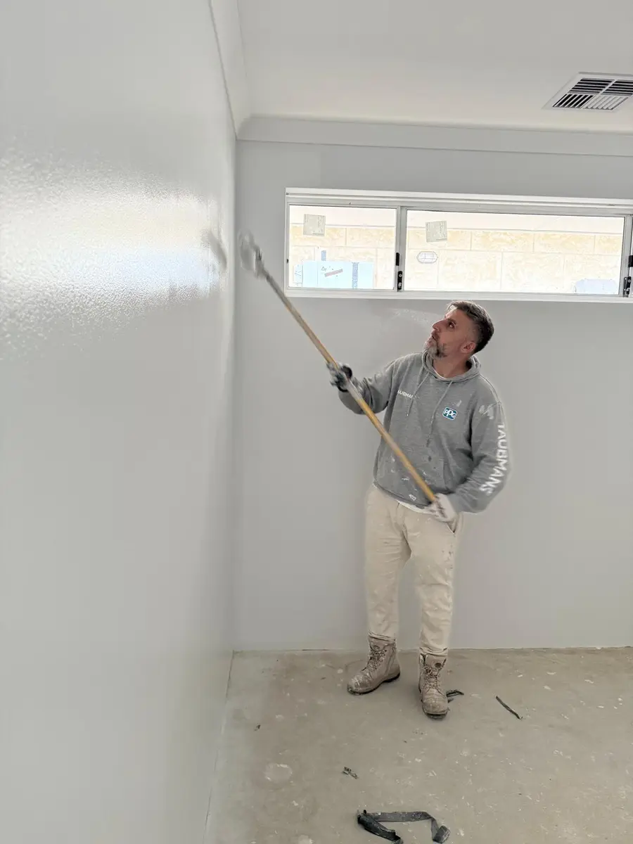 Kevin rolling interior walls with an extension pole